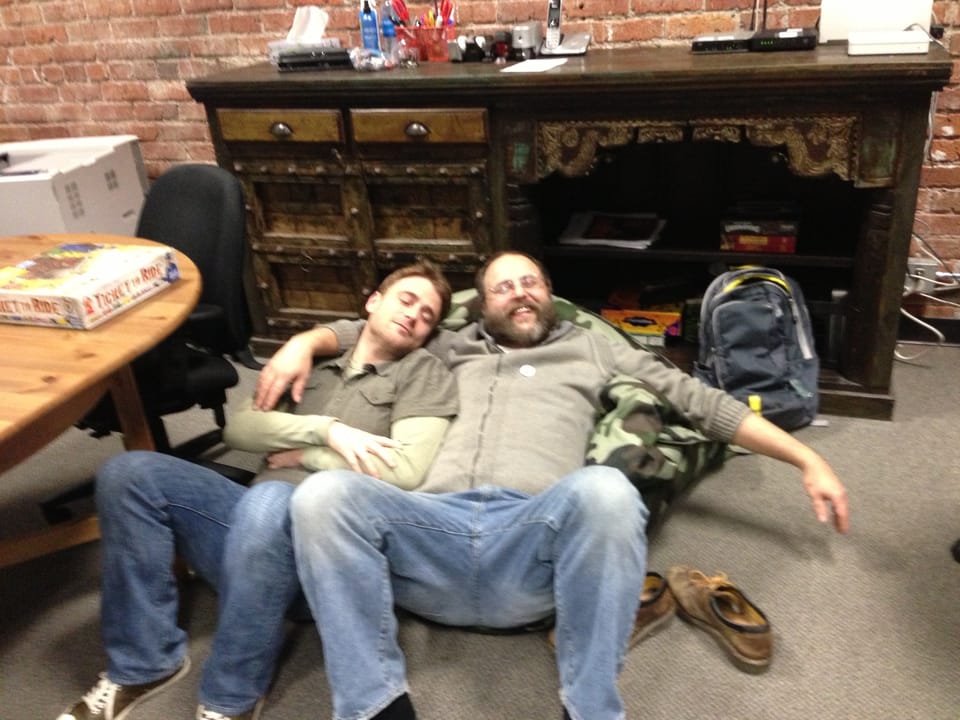 Stewart Butterfield and Eric Costello, lying on a beanba